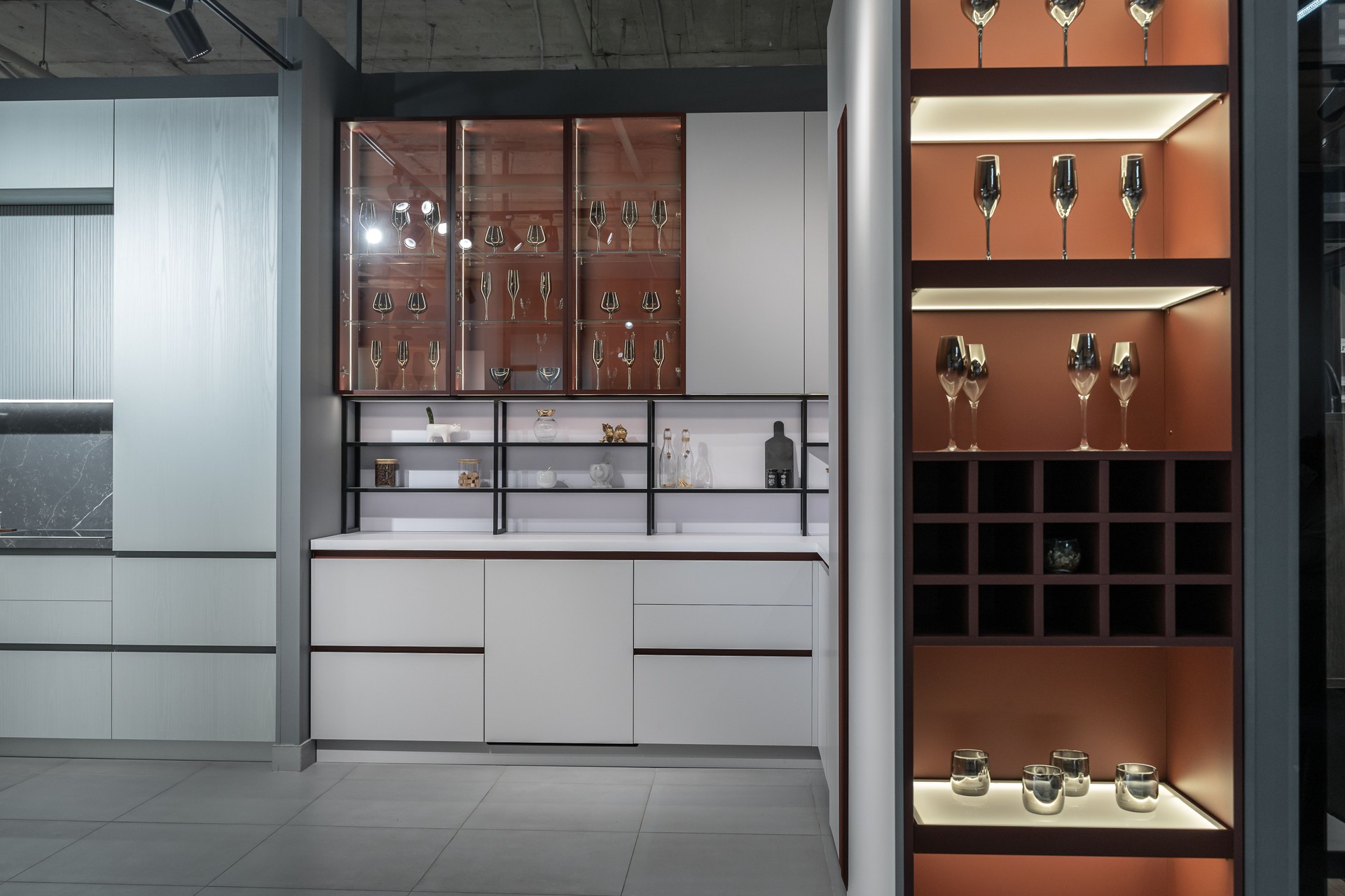 large modern built-in kitchen with lots of upper and lower cabinets, drawers and shelves. light countertop, built-in kitchen appliances, glass doors, steel faucet and sink. luxury kitchen design.